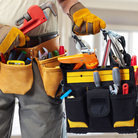 Builder handyman with construction tools. House renovation background.